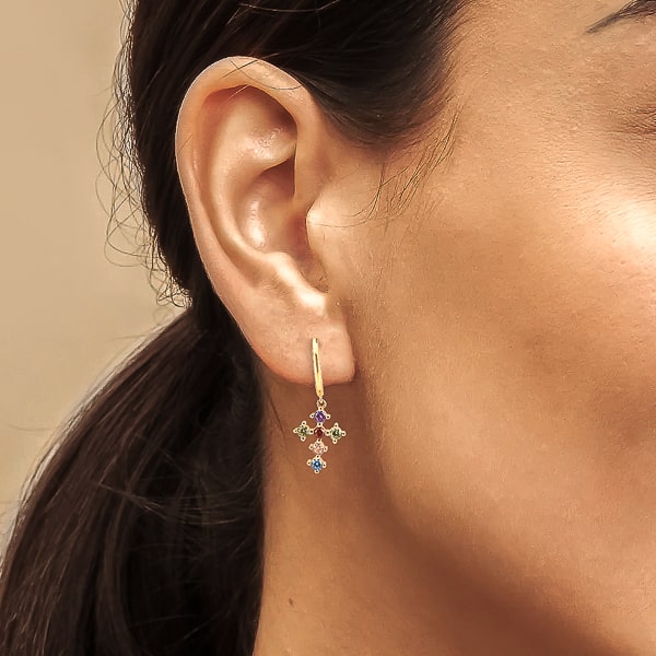 Woman wearing gold multicolor crystal cross hoop earrings