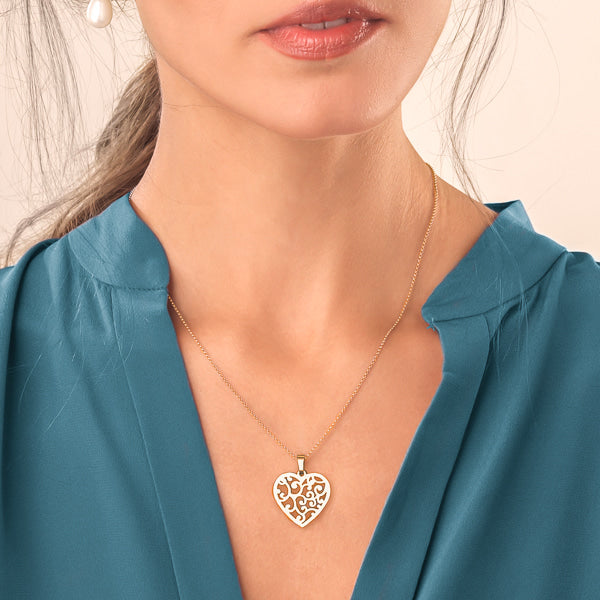 Woman wearing a gold mycelium heart pendant necklace
