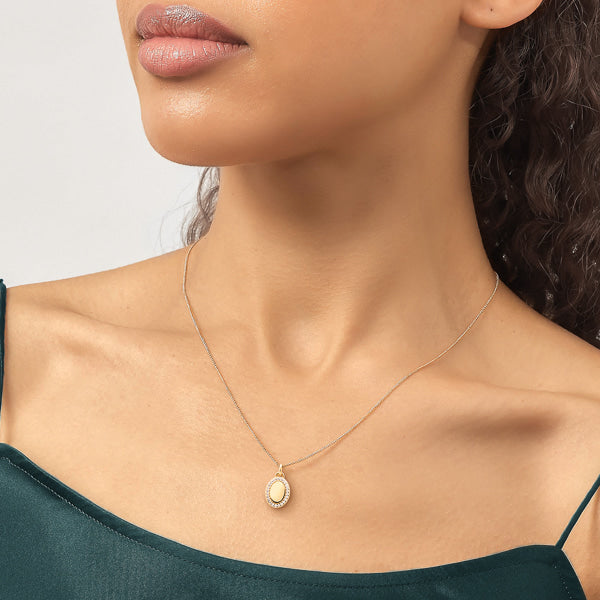 Woman wearing gold oval pendant necklace