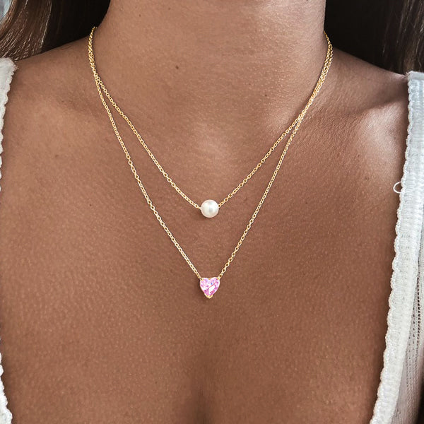 Woman wearing a gold pink crystal heart necklace