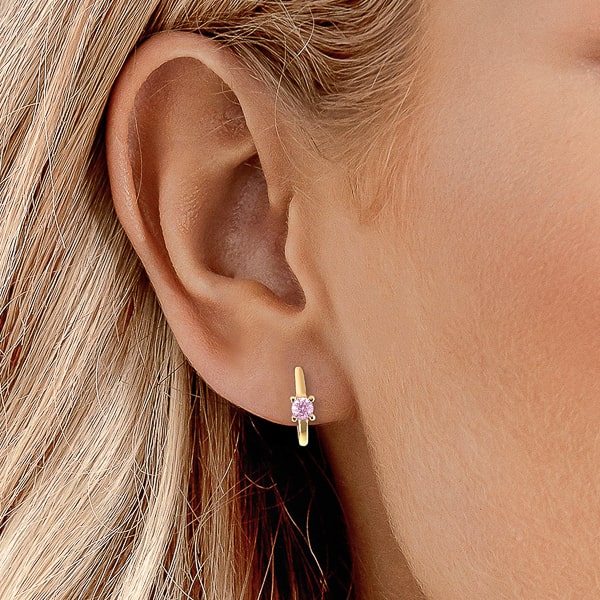 Woman wearing gold pink solitaire hoop earrings