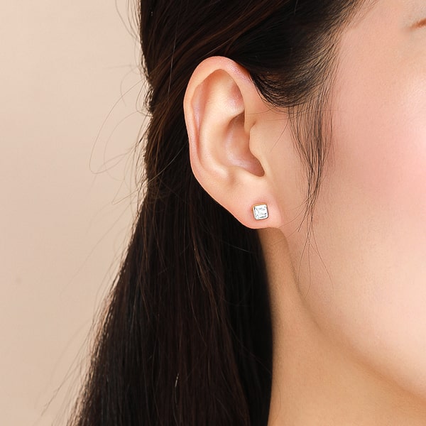 Model wearing gold princess-cut crystal stud earrings