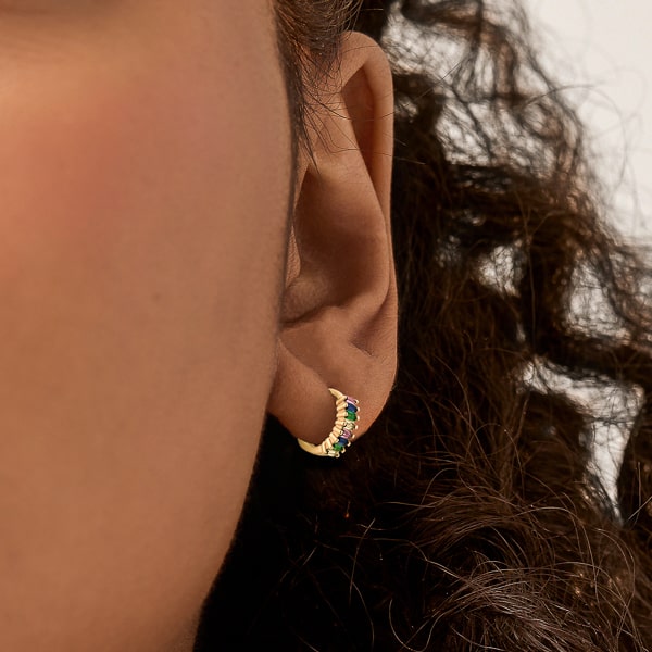 Gold rainbow emerald-cut crystal huggie earrings on model