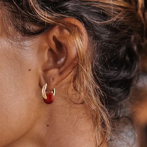 Woman wearing gold red agate hoop earrings