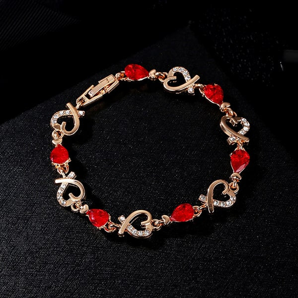Details of the gold heart chain bracelet with red crystals