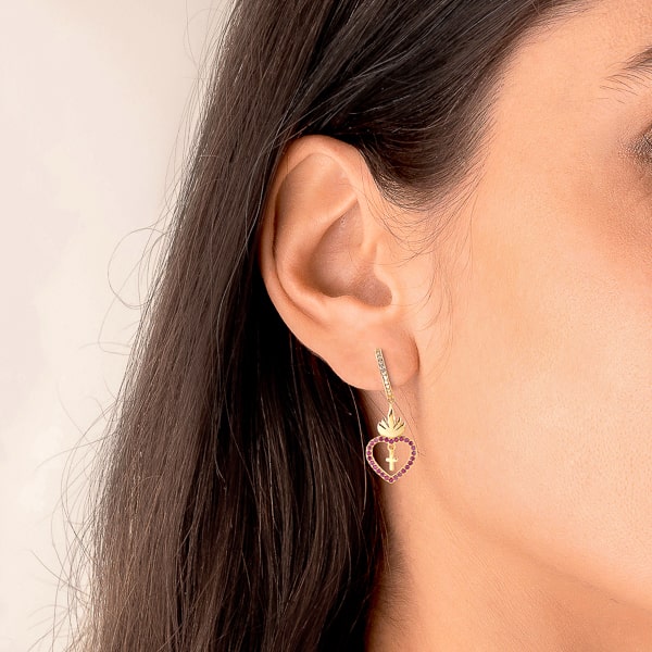Woman wearing gold sacred heart hoop earrings