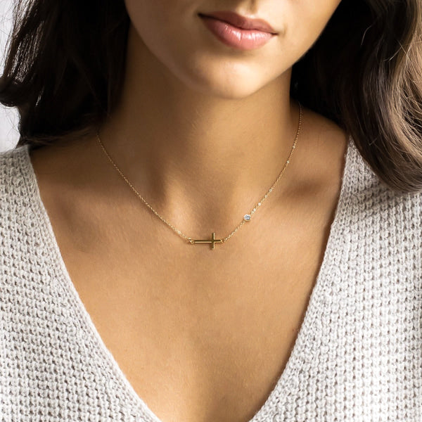 Woman wearing a gold sideways cross necklace