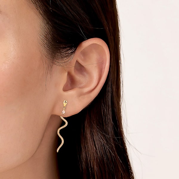 Model wearing gold snake crystal drop earrings