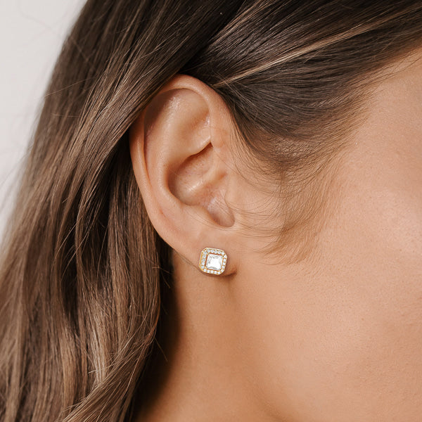 Woman wearing gold square halo stud earrings