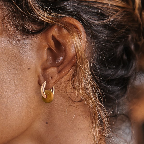 Woman wearing gold topaz hoop earrings