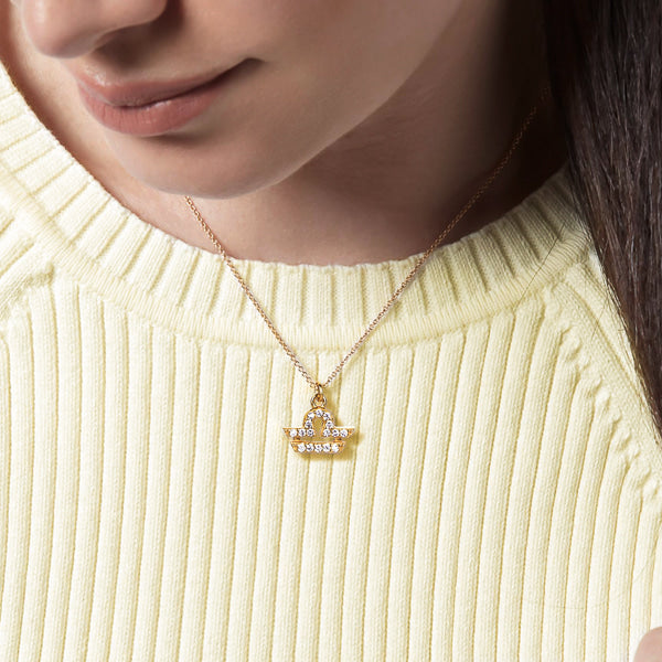 Woman wearing a gold vermeil Libra necklace