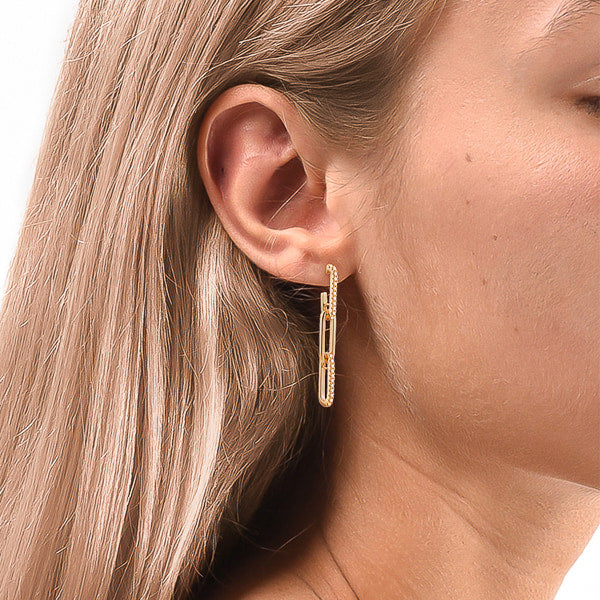 Woman wearing gold crystal link chain drop earrings