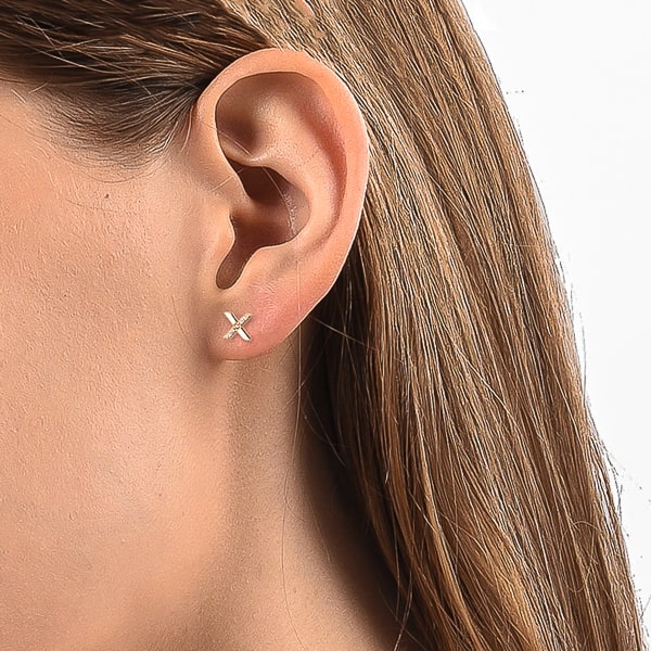 Woman wearing gold x stud earrings