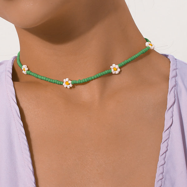 Woman wearing a green beaded daisy flower choker necklace