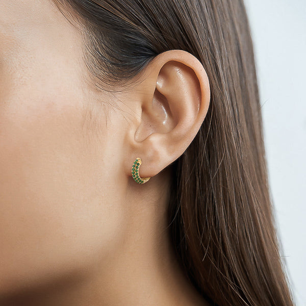 Woman wearing green cubic zirconia pavé mini hoop earrings