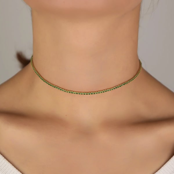 Woman wearing a green and gold tennis choker necklace