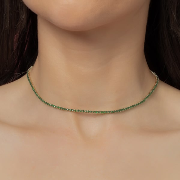 Woman wearing a green and silver tennis choker necklace