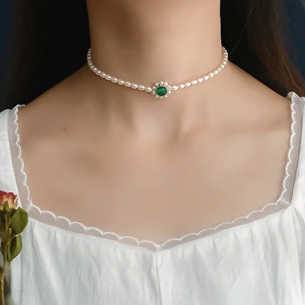 3-4mm oval pearl choker necklace with a green agate flower ornament on woman's neck