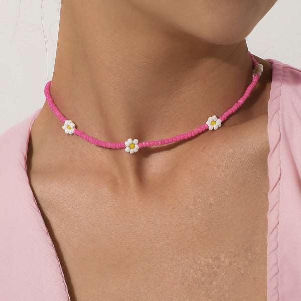 Woman wearing a hot pink beaded daisy flower choker necklace
