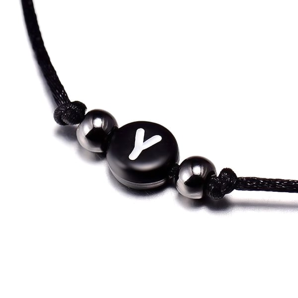 A black initial letter bead on an adjustable macrame bracelet