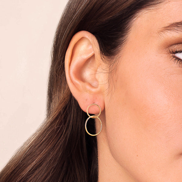 Woman wearing gold circle drop earrings