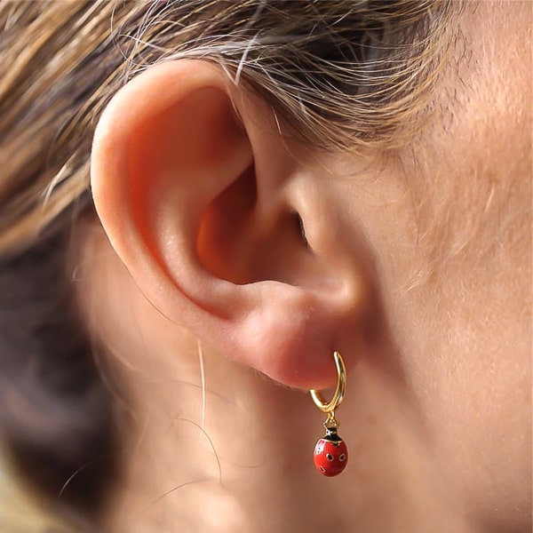Woman wearing ladybug mini hoop drop earrings
