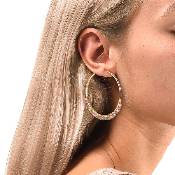Woman wearing large colorful bead hoop earrings