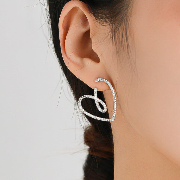 Woman wearing large sparkling crystal heart earrings