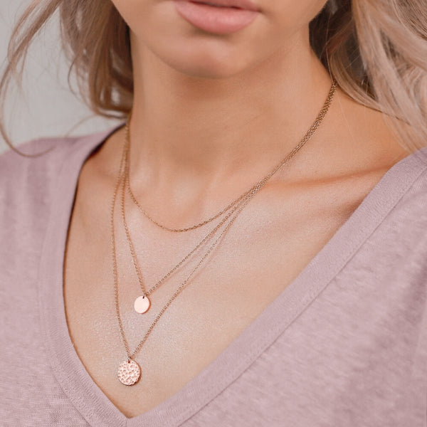 Woman wearing a rose gold layered coin pendant necklace set