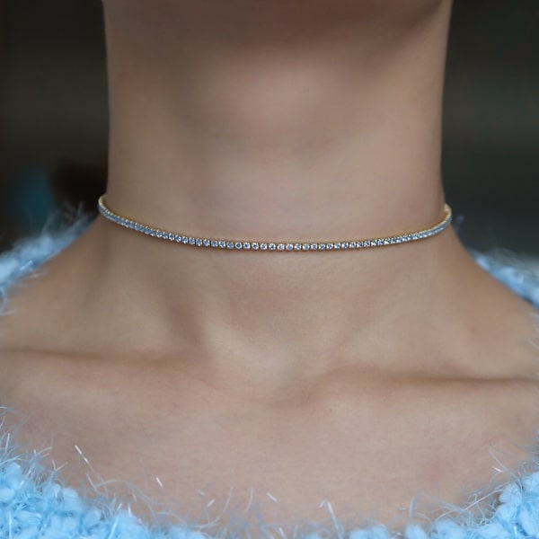 Woman wearing a light blue and gold tennis choker necklace