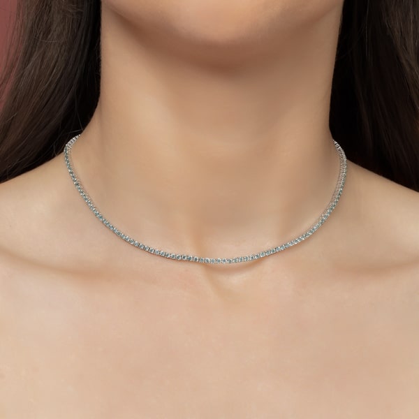 Woman wearing a light blue and silver tennis choker necklace