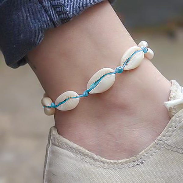 Light blue cowrie shell anklet on a womans ankle