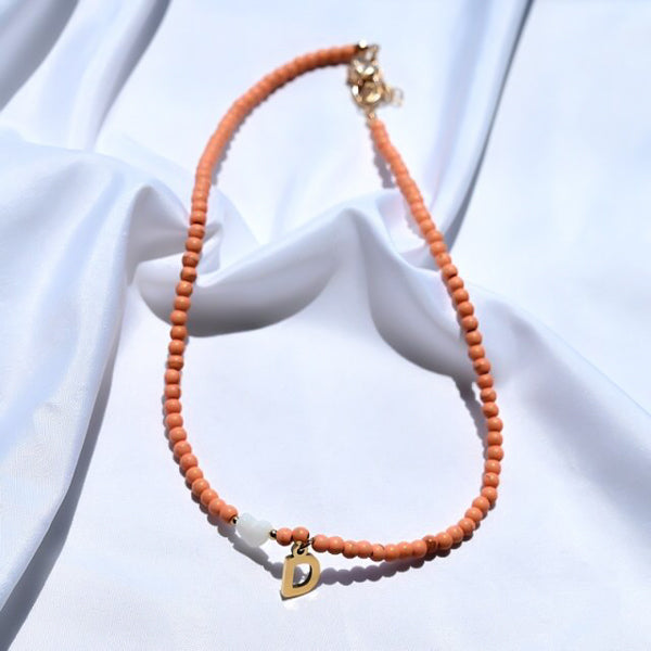 Orange beaded choker necklace with gold initial letter charm pendant
