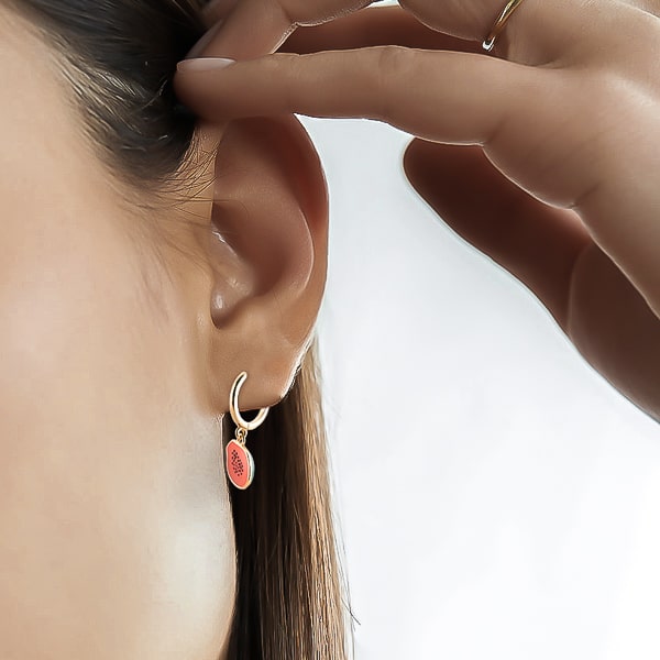 Woman wearing papaya mini hoop drop earrings