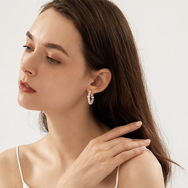 Woman wearing classic pearl hoop earrings