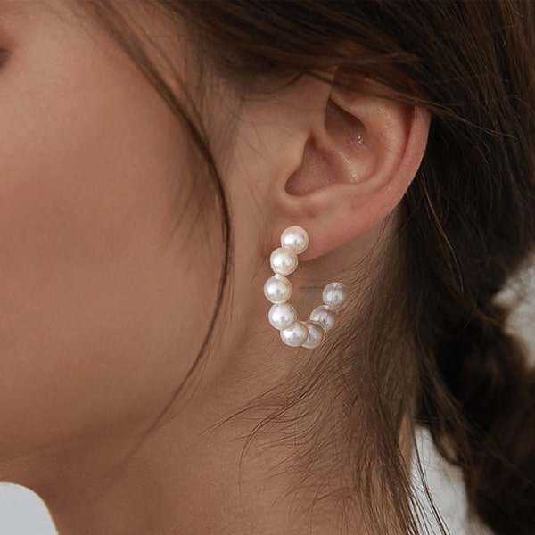 Woman wearing pearl open hoop earrings