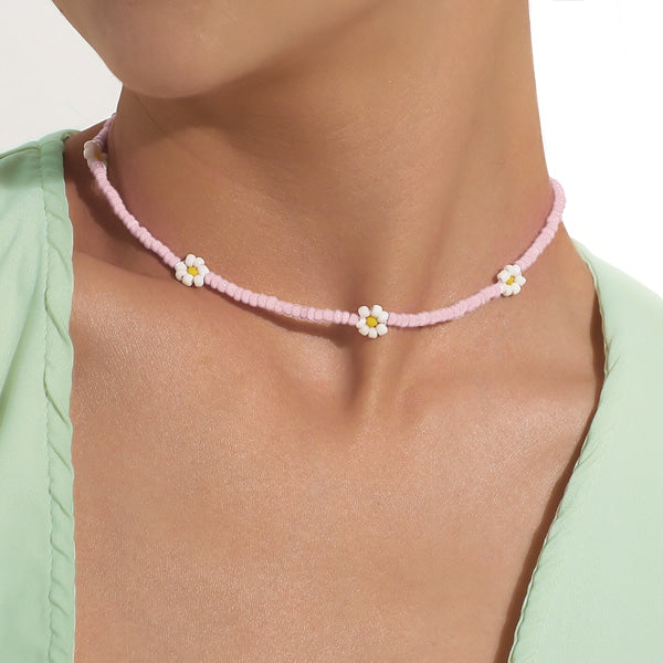 Woman wearing a pink beaded daisy flower choker necklace