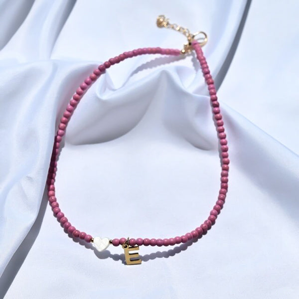 Pink beaded choker necklace with gold initial letter charm pendant