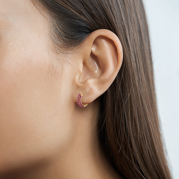 Woman wearing pink cubic zirconia pavé mini hoop earrings