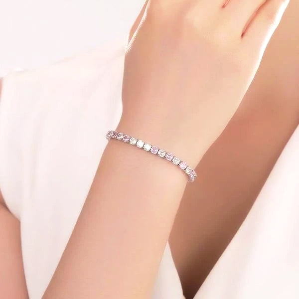 Pink cubic zirconia tennis bracelet on a woman's wrist