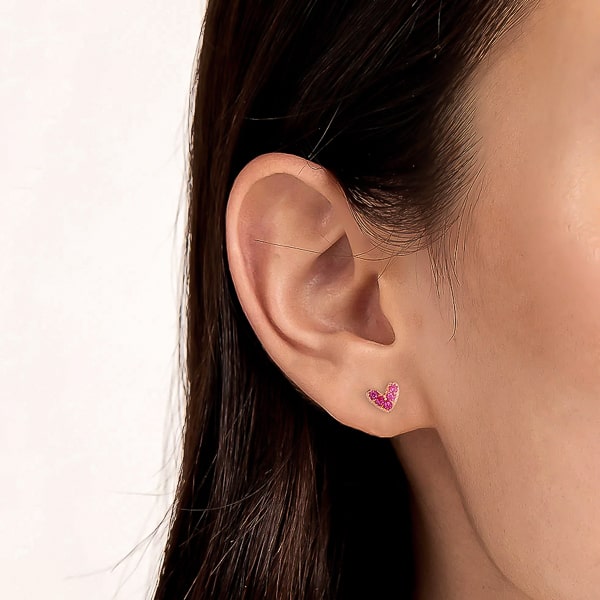Woman wearing pink crystal heart stud earrings