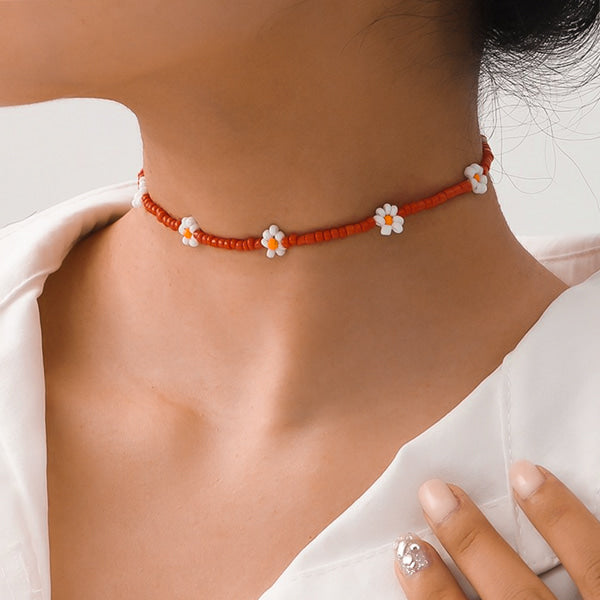 Woman wearing a red beaded daisy flower choker necklace