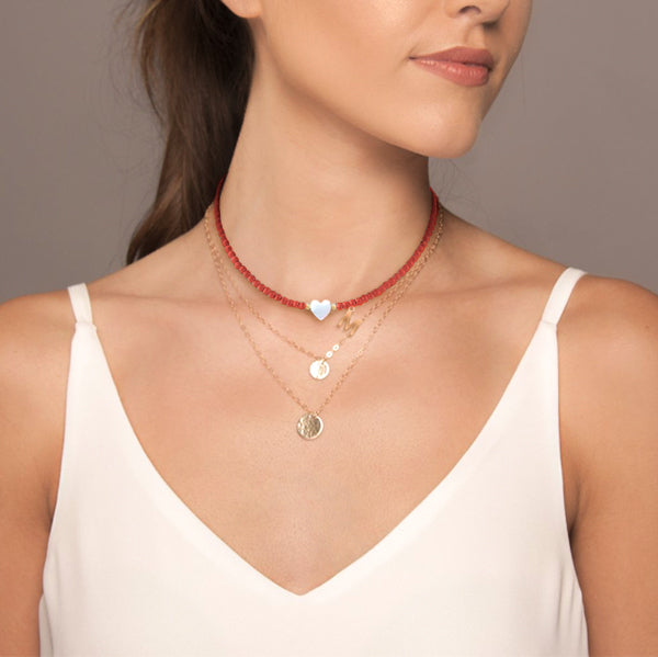 Woman wearing a red beaded initial letter choker necklace