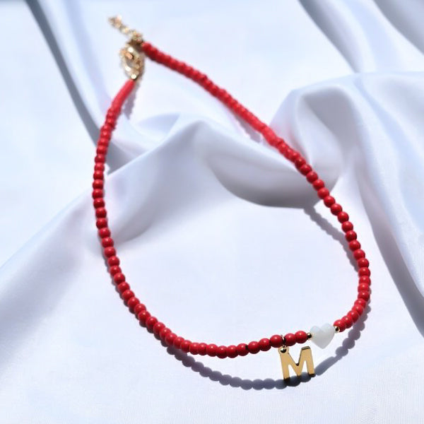 Red beaded choker necklace with gold initial letter charm pendant