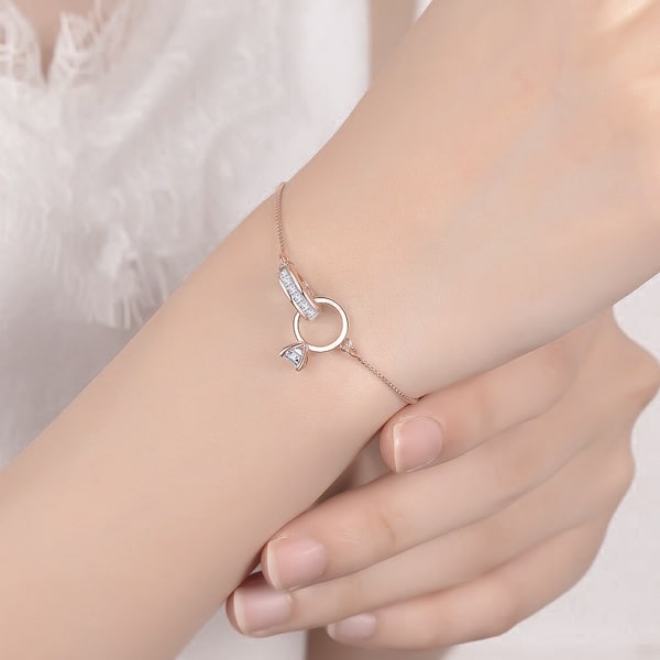Woman wearing a rose gold double-ring engagement bracelet