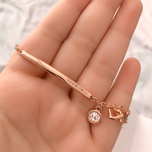 Woman holding a rose gold happiness bracelet