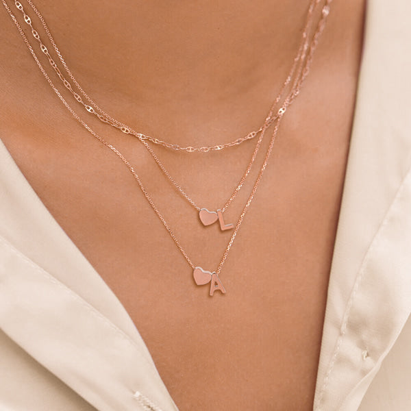 Woman wearing a rose gold heart initial letter necklace