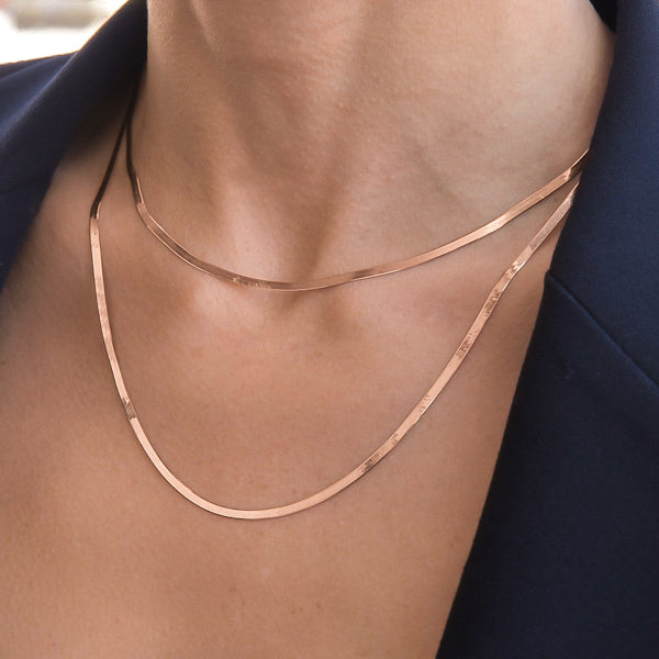 Woman wearing a 2mm rose gold herringbone chain necklace