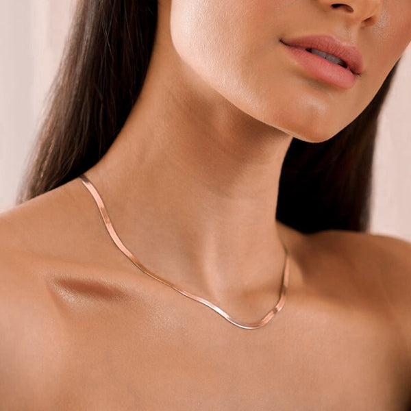 Woman wearing a 3mm rose gold herringbone chain necklace