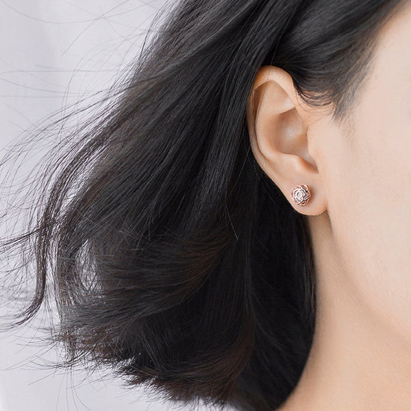 Woman wearing rose gold crystal rose flower earrings